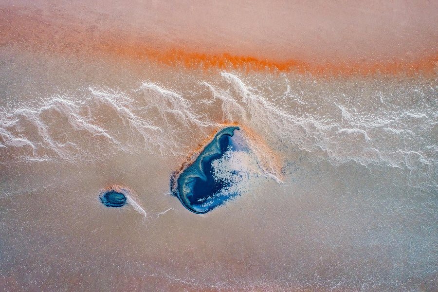 Coloured aerial of a salt lake in the Stirling Rangers. Crusty white waves of salt with  vibrant blue sections.